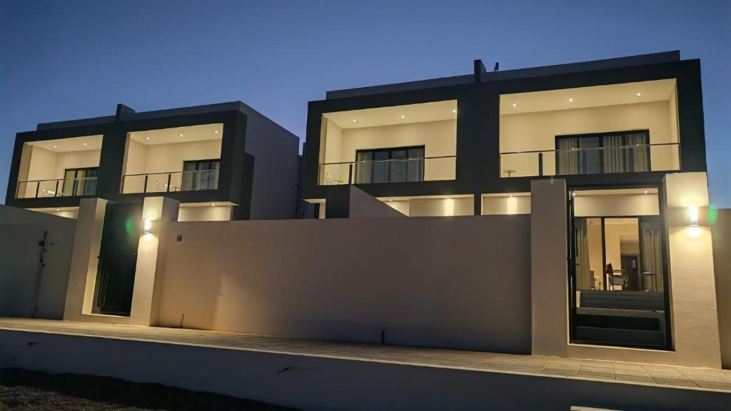 a large building with lights on the side of it at Dune View Luxury Villas in Ḩawīyah