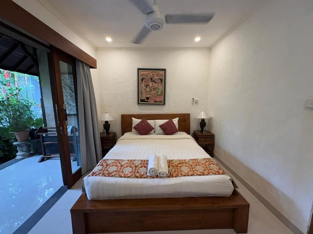 sypialnia z dużym łóżkiem i balkonem w obiekcie Annayu House Ubud w mieście Ubud