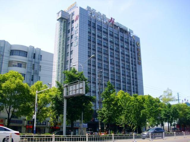 a tall building with a crane on top of it at Jinjiang Inn Nantong Gongnong Road in Nantong