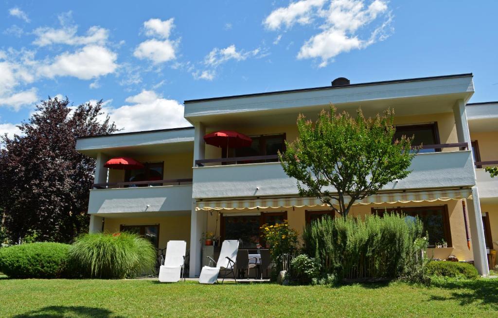 una casa con dos sillas blancas en un patio en Appartement Huber, en Merano