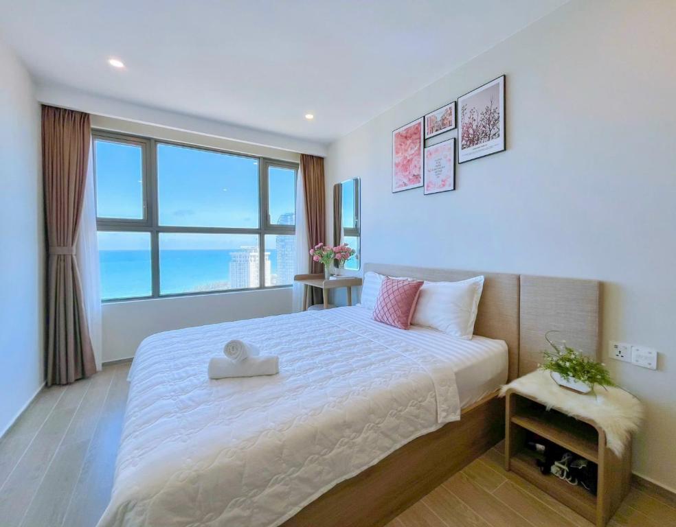 a bedroom with a large bed with a large window at The Sóng Vũng Tàu Apartment in Vung Tau