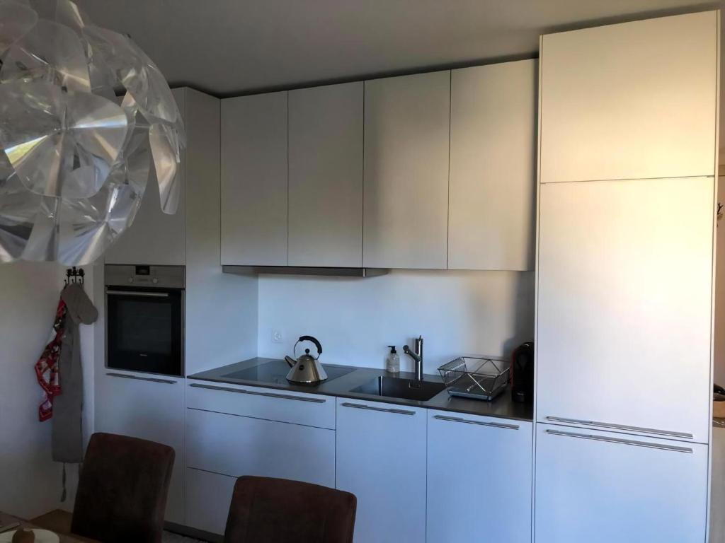 a kitchen with white cabinets and a sink at Motta Rotonda in Maloja