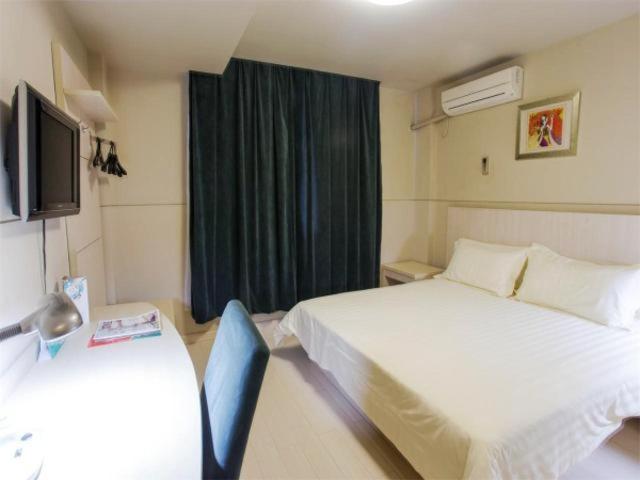 a hotel room with two beds and a television at Jingjiang Inn Wuxi Liyuan Development Zone in Wuxi