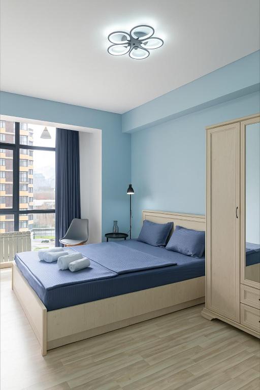 una camera da letto con un letto e un ventilatore a soffitto di Lamiya a Almaty