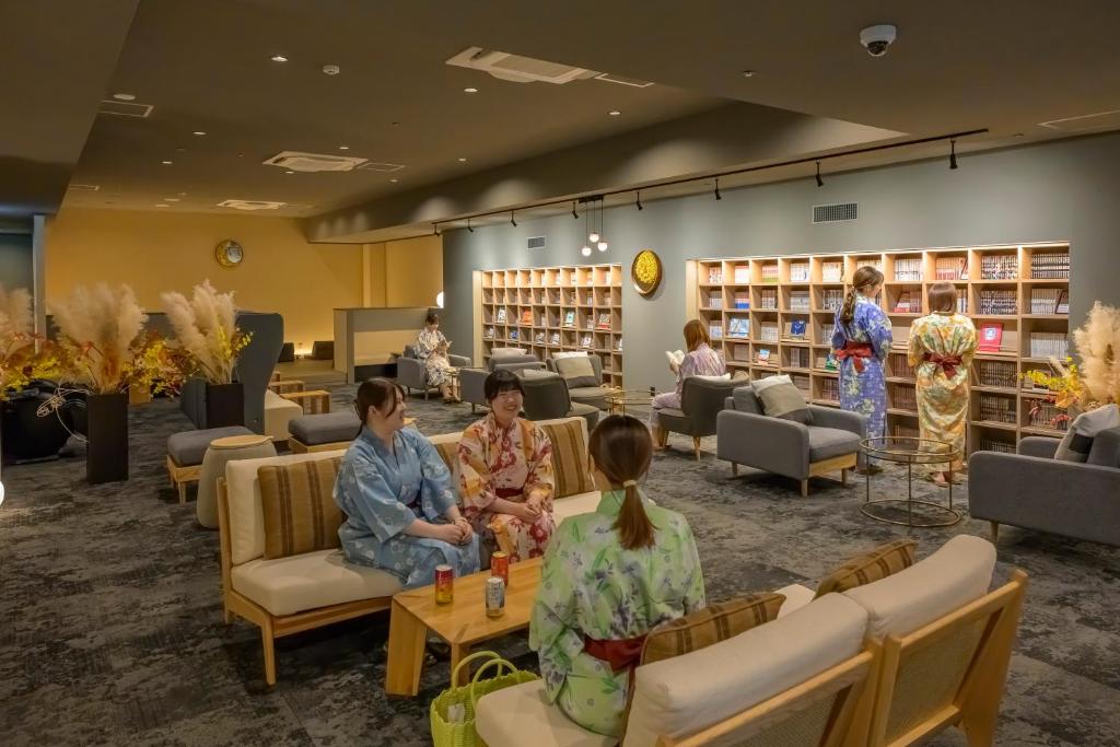 un groupe de personnes assises dans une bibliothèque dans l'établissement Tendo Hotel, à Tendō