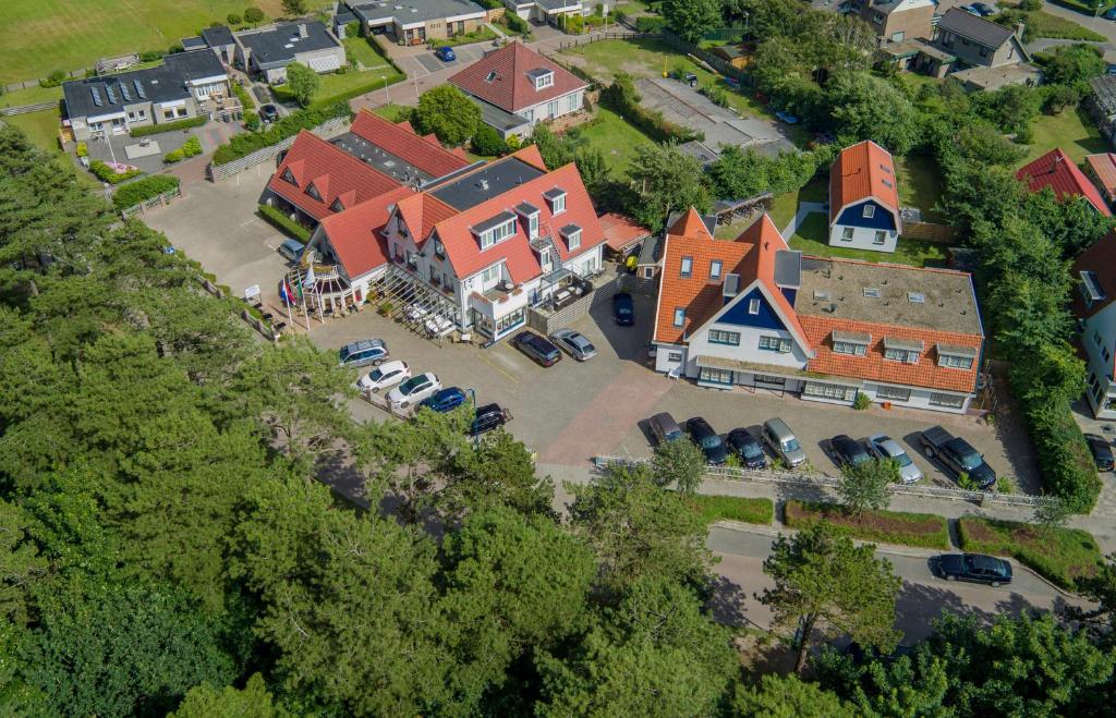 an aerial view of a large house with a parking lot at Het Uilenbos in De Koog