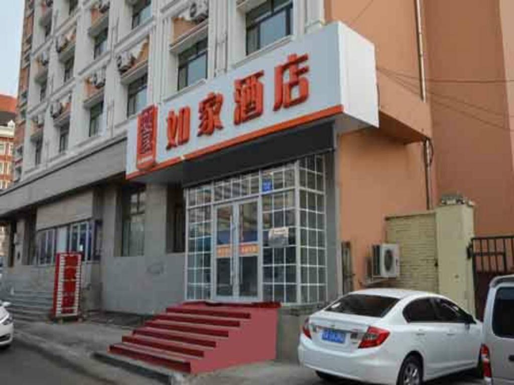 un coche blanco estacionado frente a un edificio en Home Inn Xidazhi Street Engineering University, en Harbin