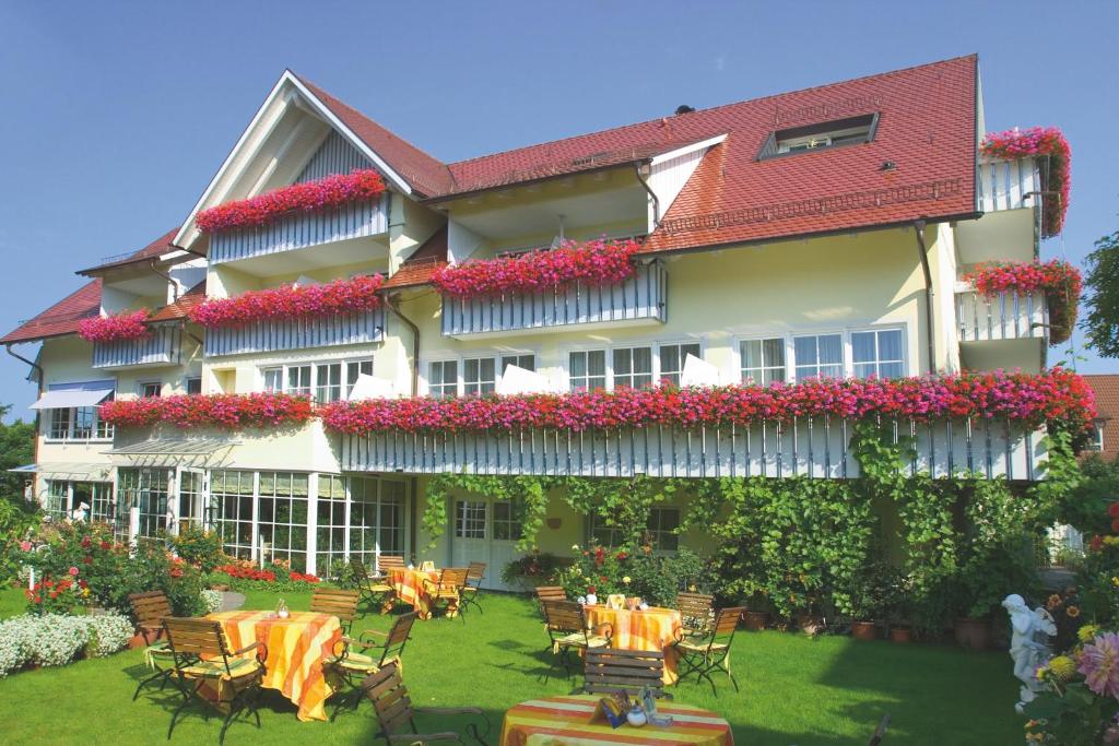 a hotel with tables and chairs in a yard at Hotel Seeperle in Langenargen