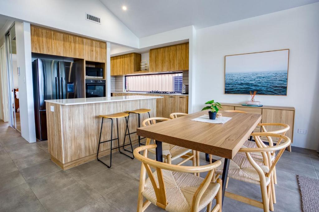 a kitchen with a wooden table and chairs at Casa Al Mare in Busselton
