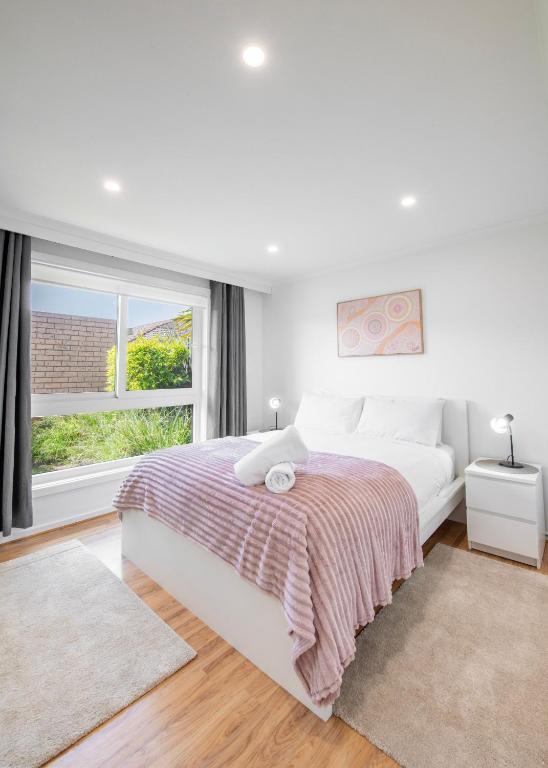 a white bedroom with a bed and a window at Rye Retro Modern Remix in Rye