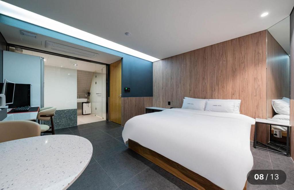 a bedroom with a large white bed and a desk at Hotel Cherry in Seoul