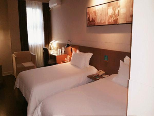 a hotel room with two beds and a desk at Jinjiang Inn Select Shanghai Nanxiang Minzhu Street in Jiading