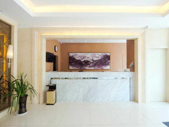 een lobby met een grote balie in een gebouw bij Jinjiang Inn Xianning Yinquan Avenue Hot Spring Hotel in Xianning