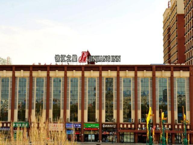 un gran edificio con un cartel encima en Jinjiang Inn Daqing Honggang en Daqing