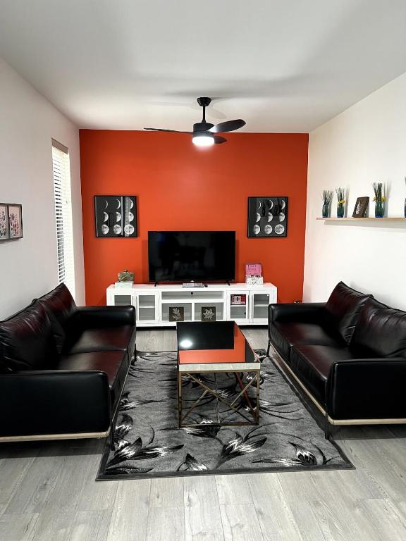 a living room with two leather couches and a flat screen tv at OranGe DeLuxe in Omaha
