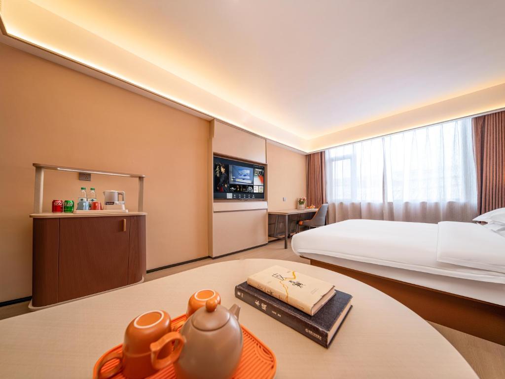 une chambre d'hôtel avec un lit et une table dans l'établissement Taiyuan Yuehang Zhenhua Hotel, à Taiyuan