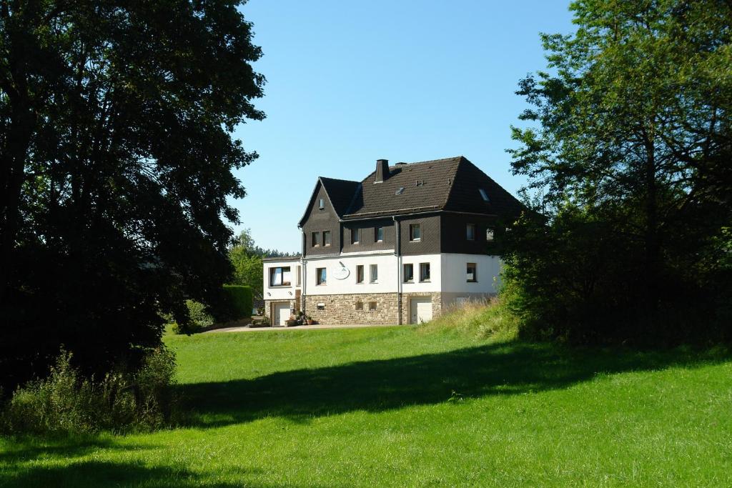 a large house on top of a green field at Haus Hesseberg in Medebach