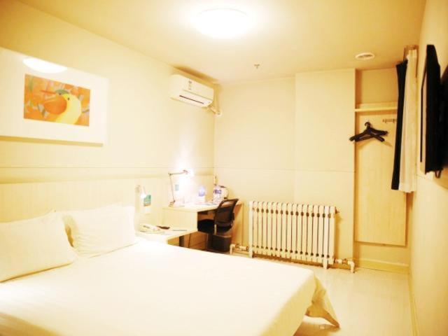 a bedroom with a white bed and a desk at Jinjiang Inn Jinzhou Yunfei Bridge in Jinzhou