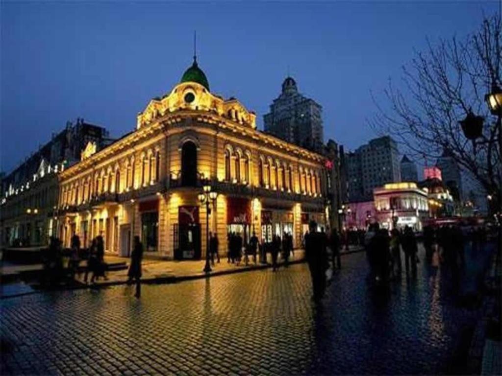 哈尔滨7 Days Inn Harbin West Railway Station的夜晚城市里灯火通明的建筑