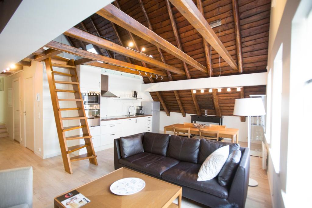 een woonkamer met een leren bank en een tafel bij Frogner House - Sølvberggata 17 in Stavanger