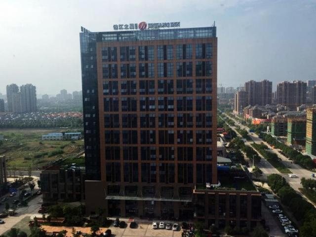 un edificio alto con un cartel en la parte superior en Jinjiang Inn Select Jiaxing Wanda Plaza en Jiaxing