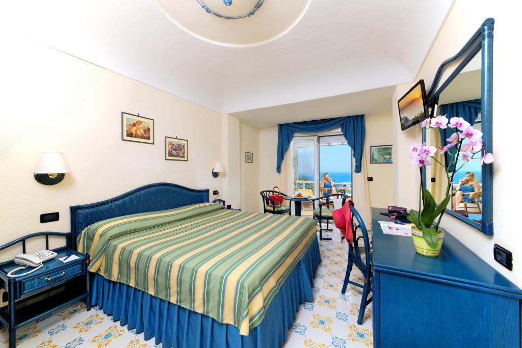 a hotel room with a bed and a desk and a table at Sorriso Thermae Resort & Spa in Ischia