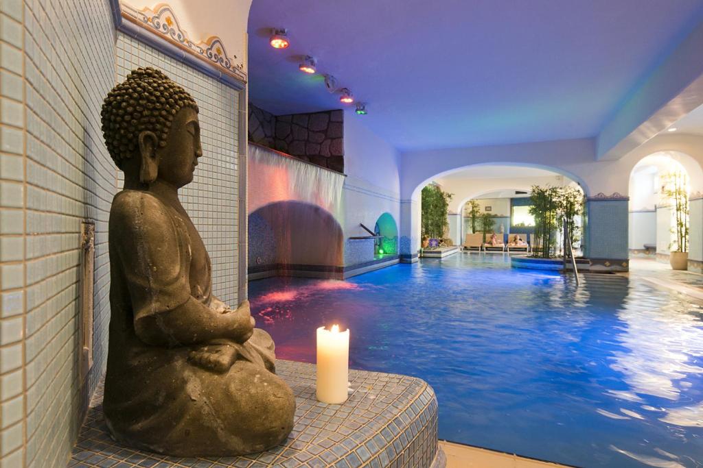 a statue of a buddha sitting next to a pool at Sorriso Thermae Resort & Spa in Ischia
