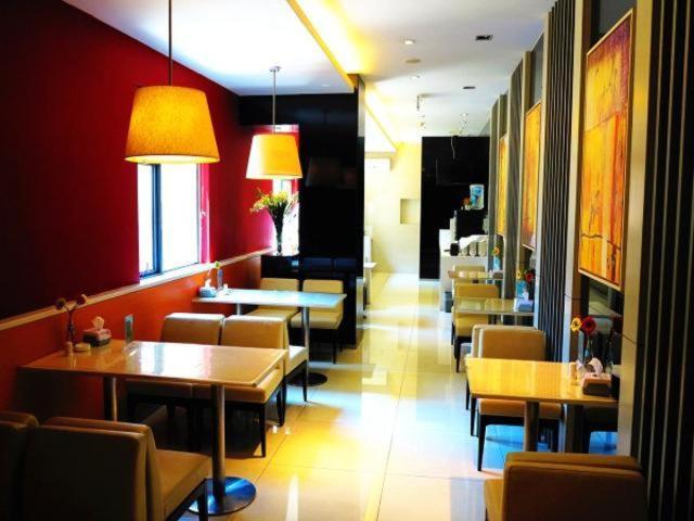 um restaurante com mesas e cadeiras num quarto em Jinjiang Inn Hefei Huizhou Avenue em Hefei