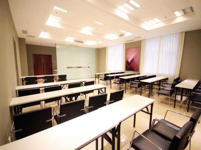 una sala vacía con mesas y sillas en un aula en Jinjiang Inn Langfang High-speed Railwy Station Yinhe South Road, en Langfang
