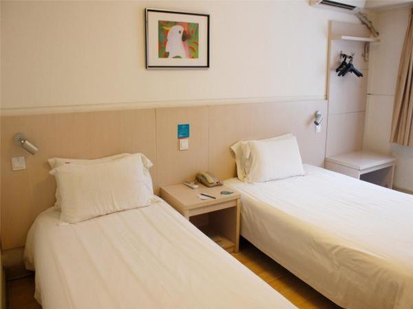 a hotel room with two beds and a telephone at Jingjiang Inn Xi'an Jianguomen in Xi'an