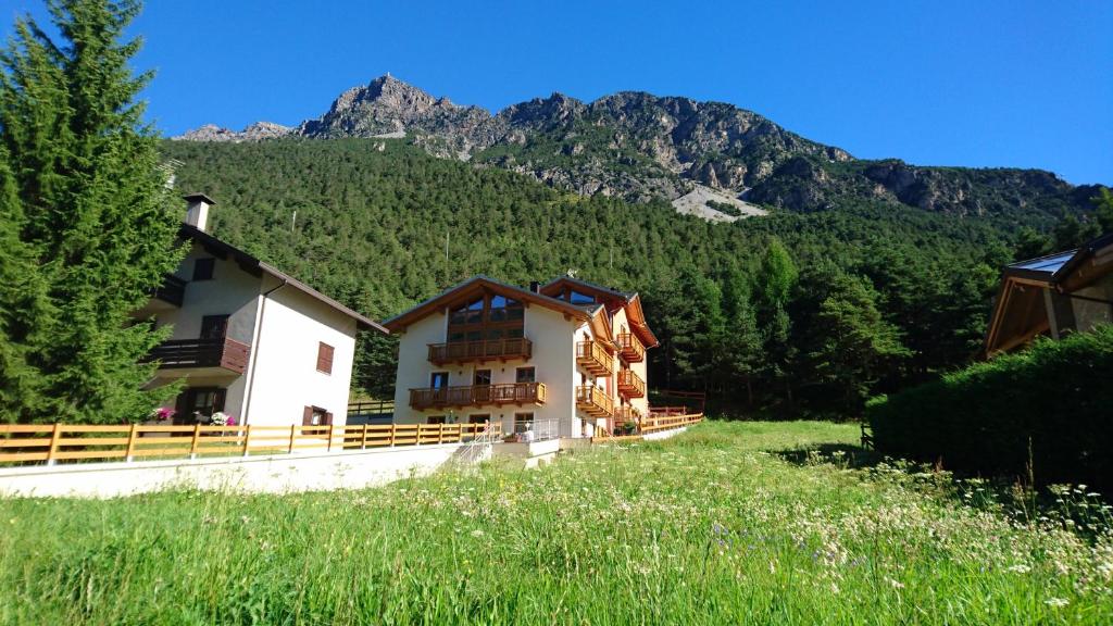 ein Haus auf einem Feld mit Bergen im Hintergrund in der Unterkunft SoleLuna in Valdidentro