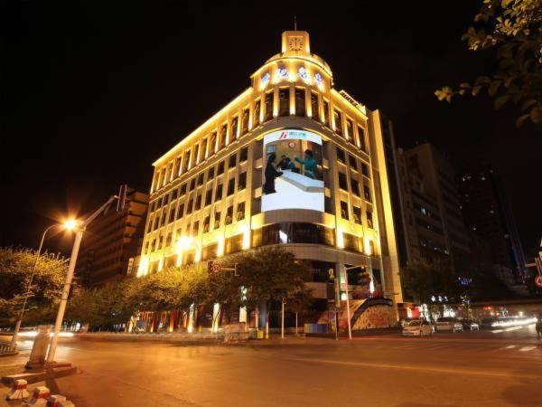 烏魯木齊的住宿－錦江之星烏魯木齊紅旗路酒店，一座大建筑,上面有灯,晚上