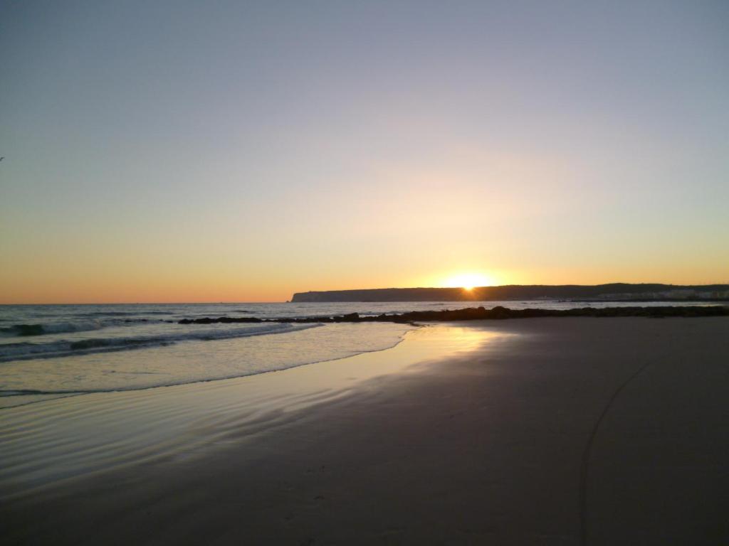 a sunset on a beach with the ocean at Casa Entre Armonías in Zahara de los Atunes