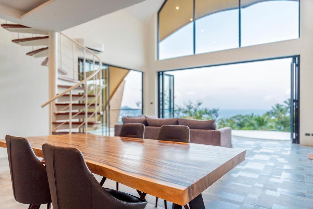 a dining room with a wooden table and chairs at Villa Azure in Koh Samui 
