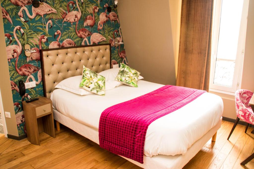 sypialnia z łóżkiem z różowym kocem w obiekcie Excelsior Batignolles w Paryżu