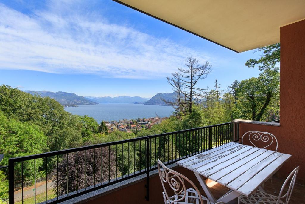 a balcony with a wooden bench and a view of a lake at Ca' del Bosco in Stresa
