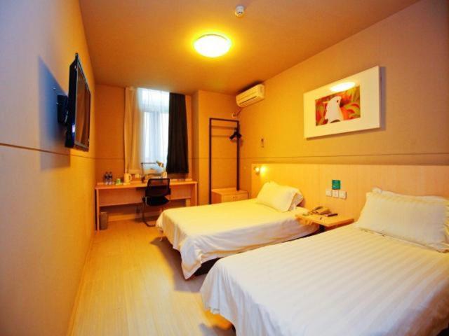um quarto de hotel com duas camas e uma secretária em Jingjiang Inn Hefei Hi-tech Park West Changjiang Road em Hefei