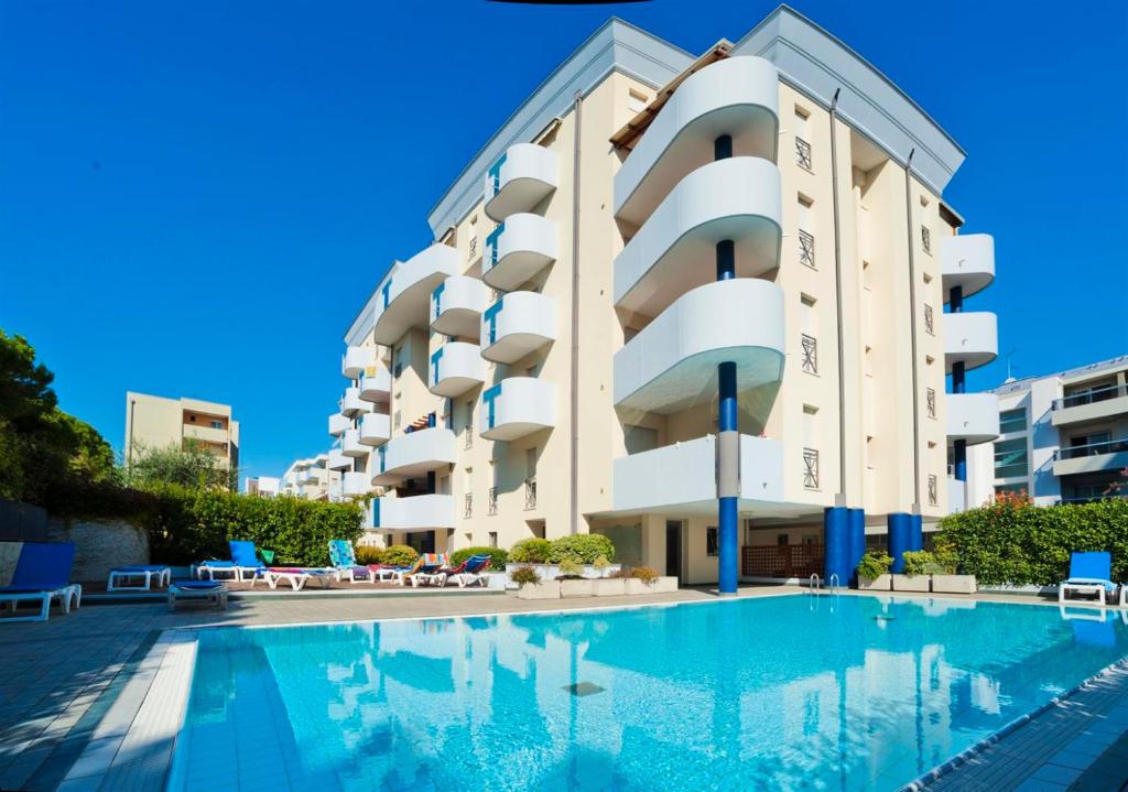 un hotel con piscina di fronte a un edificio di De La Mariute a Bibione