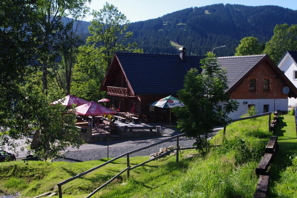 stodoła ze stołami i parasolami przed nią w obiekcie Penzion Avalanche w mieście Železná Ruda