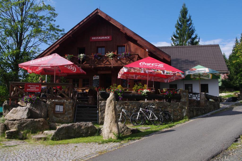 a restaurant with umbrellas and bikes in front of a building at Penzion Avalanche in Železná Ruda