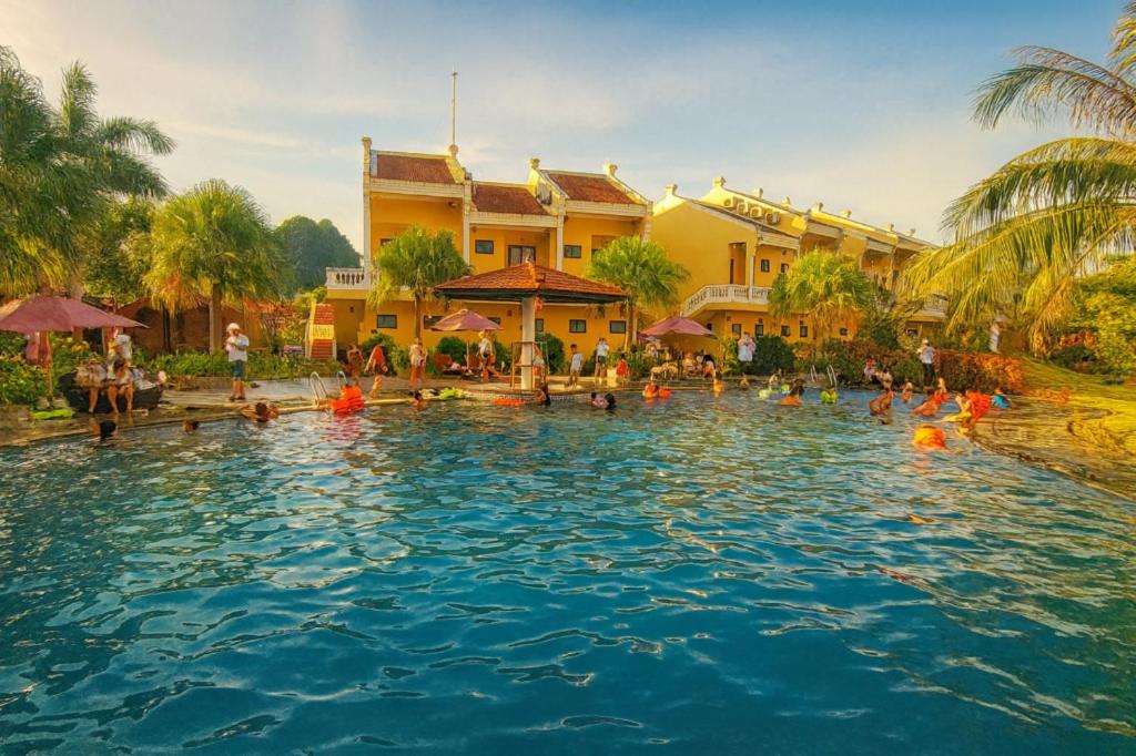 ein Pool in einem Resort mit Menschen im Wasser in der Unterkunft Doan Gia Resort in Cừ Lạc