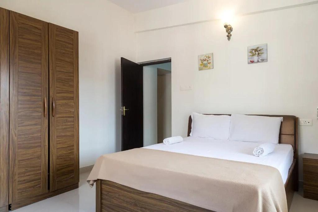 a bedroom with a bed and a wooden cabinet at 1bhk Premium BS1 - Candolim Calangute Area in Candolim