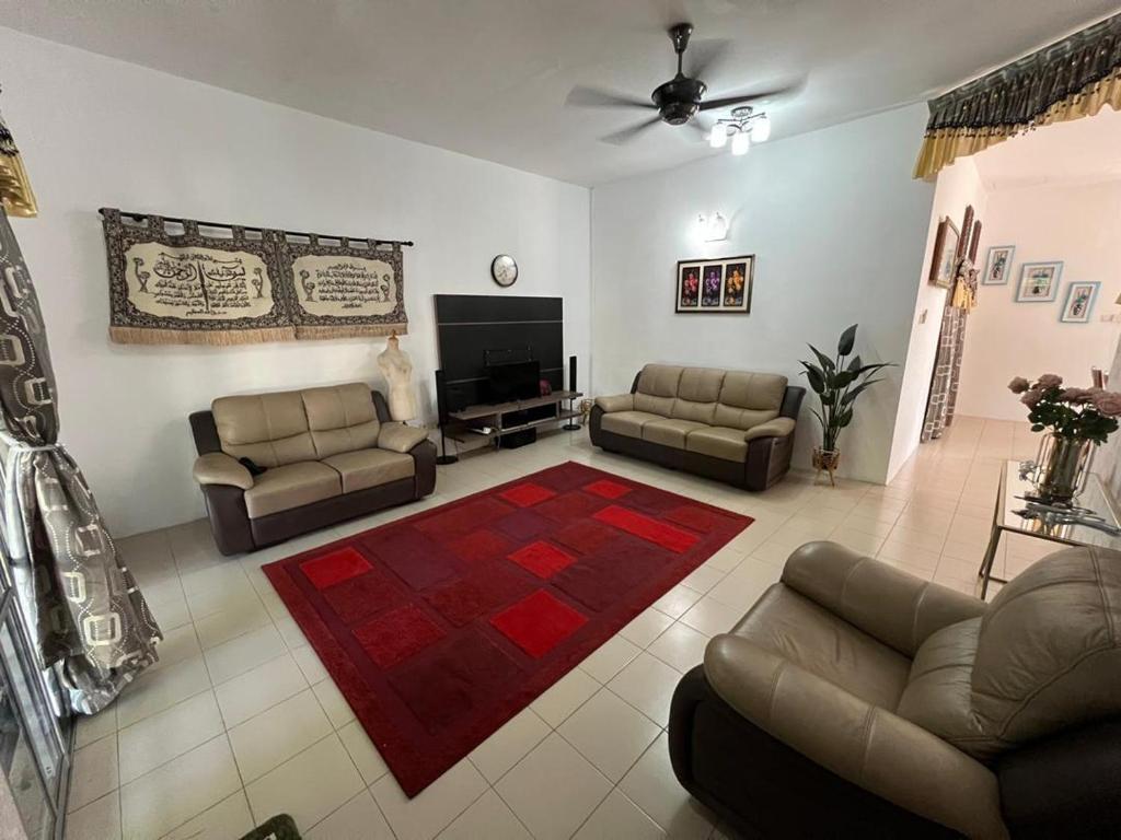 a living room with couches and a flat screen tv at Homestay Anjung Desa in Kuantan