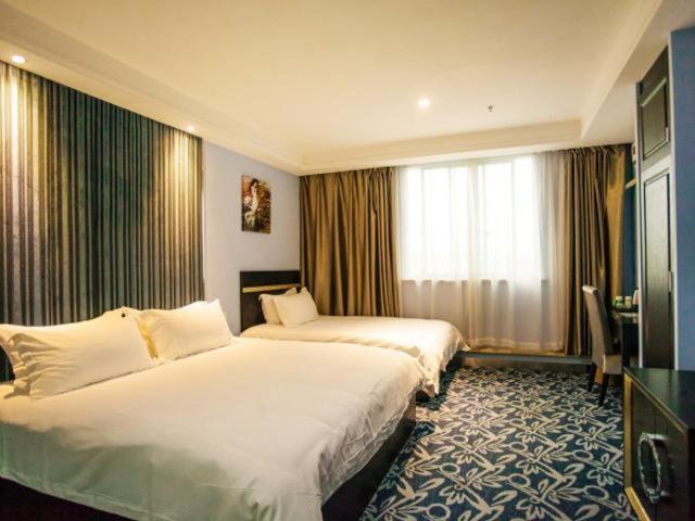 a hotel room with two beds and a large window at Goldmet Inn Wuxi Gonghu Avenue Wanxiangcheng in Wuxi