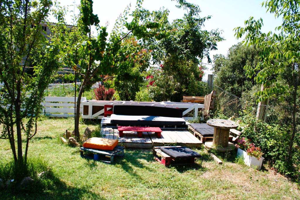 a yard with a group of chairs in the grass at Tantaka - Albergue Los Meleses in Radiquero