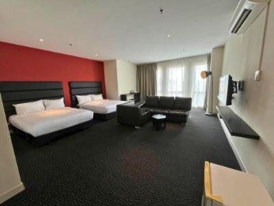 a hotel room with two beds and a couch at Estella Hotel in Pelabohan Klang