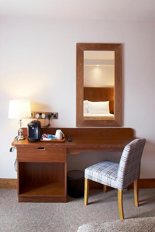 a desk with a mirror and a chair in a room at Clody Lodge in Bunclody