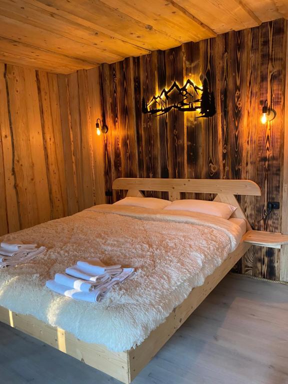 a bedroom with a bed with a wooden wall at Будиночок між річками Гирло in Iltsi
