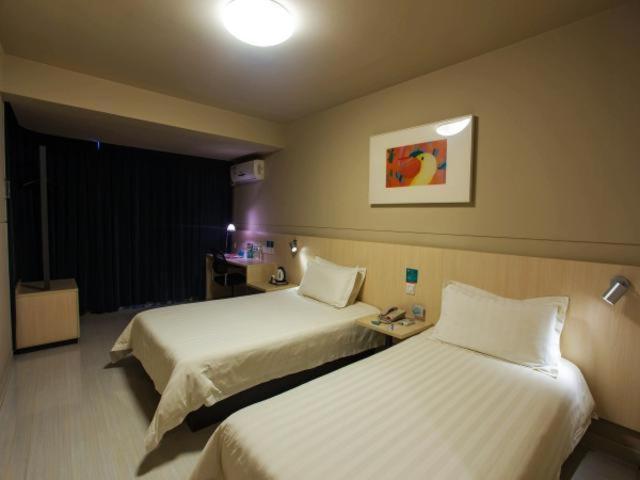 a hotel room with two beds in a room at Jinjiang Inn Nanjing Maigao Bridge in Nanjing