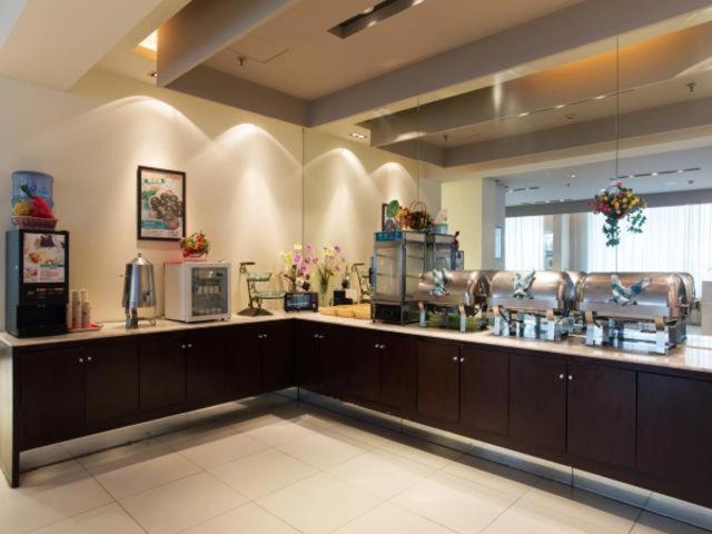 a large kitchen with brown cabinets in a large room at Jinjiang Inn Nanjing Zhonghuamen in Nanjing